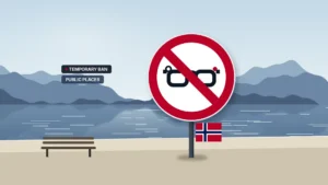 News illustration: a calm Norwegian fjord shoreline with mist-blue mountains, still water, a beach and a park bench; a large red prohibition sign on a post shows camera glasses with a record dot under a red slash, with a small Norwegian flag below; chips TEMPORARY BAN and PUBLIC PLACES.