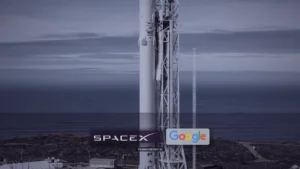 Photo of a SpaceX Falcon 9 on a coastal Vandenberg launch pad with its white strongback, graded midnight plum and steel. Small SpaceX and Google marks sit near the lower center; a quiet strap reads TRANSPORTER-18. No masthead, LATEST pill, or chip row.
